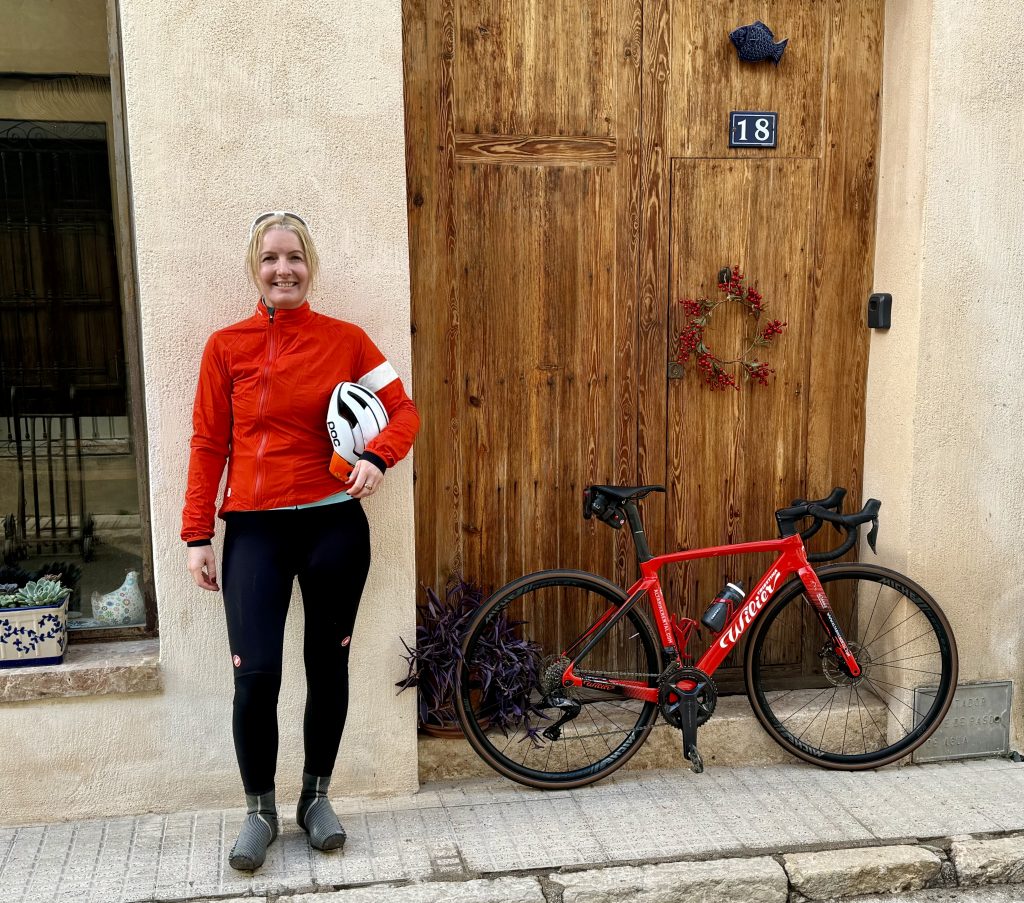 Anna Lowe in Team VV kit next to bike